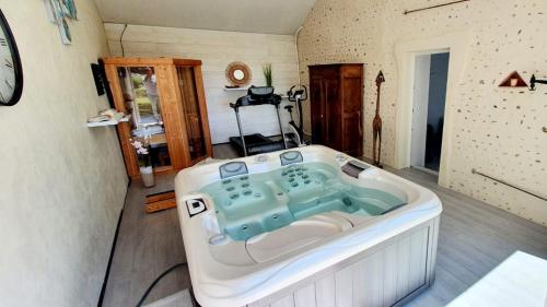 a large bath tub sitting in a room at Villa du Bonheur - 10 pers. - Spa - Sauna - Hammam 