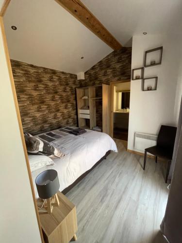 - une chambre avec un lit et un mur en briques dans l'établissement Chez manu, à Cahuzac-sur-Vère
