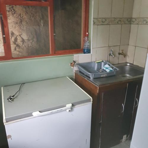a small kitchen with a sink and a counter at Fishermen s Cave in Port St Johns