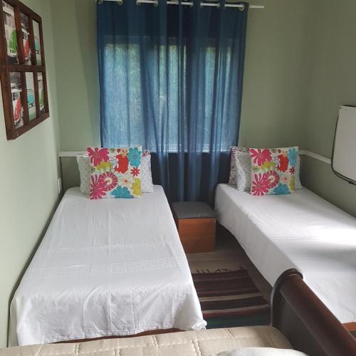 two beds in a room with a window at Fishermen s Cave in Port St Johns