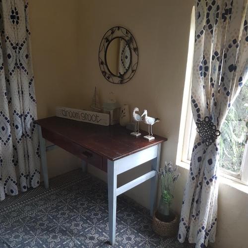 a dressing table in a room with a mirror and a window at Fishermen s Cave in Port St Johns