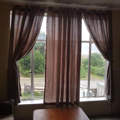 a bedroom with a window with curtains and a bed at Fishermen s Cave in Port St Johns