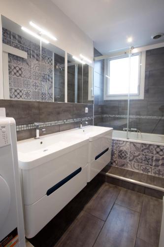 La salle de bains est pourvue d'un grand lavabo blanc et d'une baignoire. dans l'établissement Hossegor - Lumineux - Plage 100m - Surf - Lac, à Soorts-Hossegor