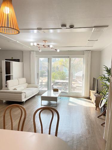 a living room with a white couch and a table at Gla Aewol in Jeju