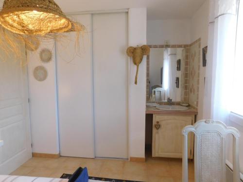uma casa de banho com um lavatório e uma porta com um espelho em Chez Marie em Régusse