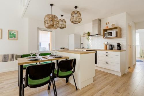 - une cuisine avec une table et des chaises vertes dans l'établissement Angelina 2 minutes de la vieille ville, à Annecy