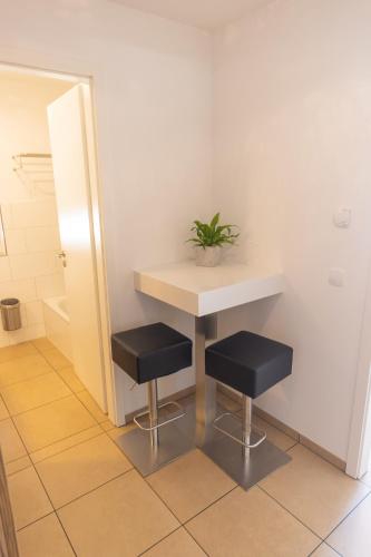 a bathroom with a table and two black stools at Boardinghouse HOME - adults only - in Konstanz