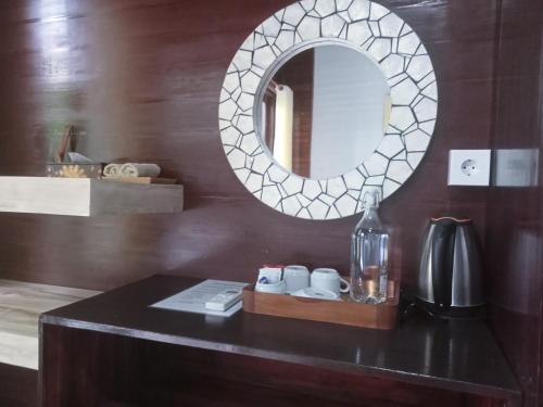 a bathroom with a mirror and a table with cups at Penida Dream Homestay and hostel in Nusa Penida