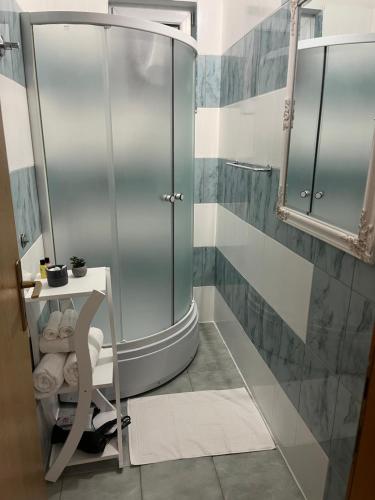 een badkamer met een douche en een stoel. bij Apartman Antony in Čitluk
