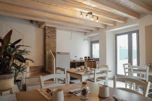 una sala da pranzo con tavoli e sedie bianche di Cà Nova B&B a Rivoli Veronese