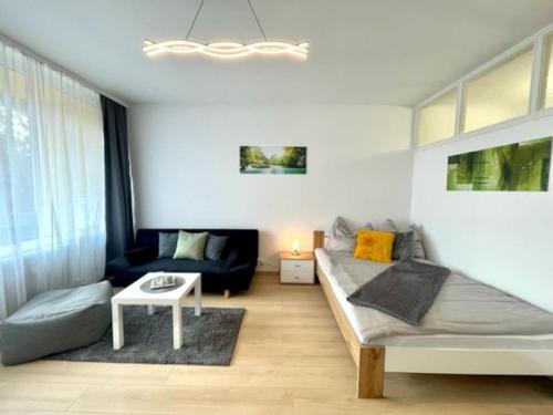 a living room with a bed and a couch at **Modernes Apartment in zentraler Lage** in Graz