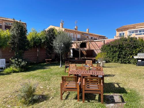 a group of chairs and a wooden table in a yard at Anna's garden in Torrevieja