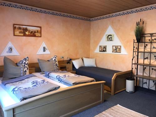 1 dormitorio con 2 camas y sofá en Moselpension Gwosch, en Bruttig-Fankel