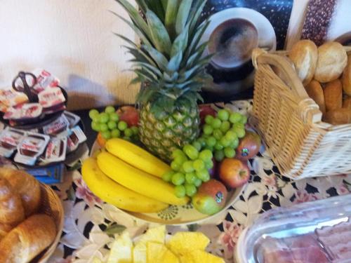 a table topped with a bowl of fruit and a pineapple at Moselpension Gwosch in Bruttig-Fankel