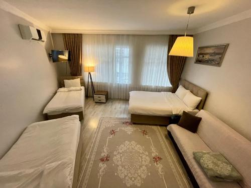 イスタンブールにあるOldtown Sultanahmet Suitesのベッド2台とソファが備わるホテルルームです。