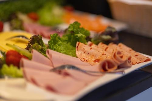 a plate of food with meat and vegetables on a table at Boardinghouse HOME - adults only - in Konstanz