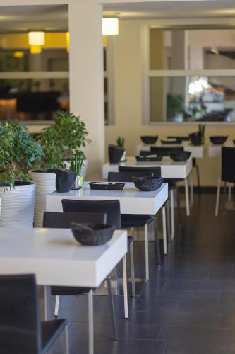 a row of white tables with plants on them at Boardinghouse HOME - adults only - in Konstanz