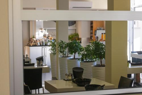 a dining room with tables and chairs and plants at Boardinghouse HOME - adults only - in Konstanz