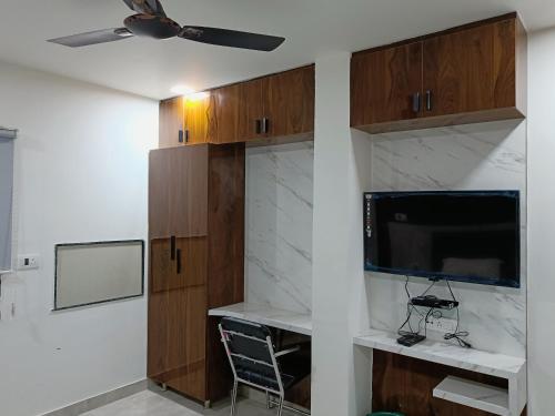 a room with a tv and a wall with wooden cabinets at Hotel Imperial Crown in Rewāri