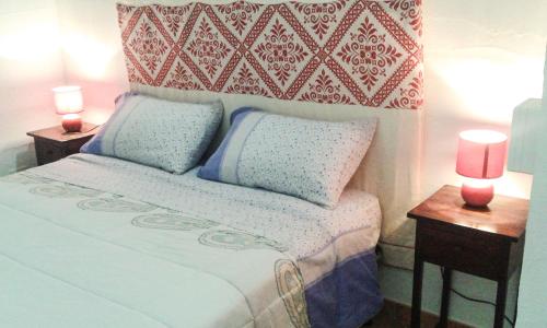 ein Schlafzimmer mit einem Bett mit zwei Nachttischen und zwei Kerzen in der Unterkunft La Terrazza Fiorita in Nebida