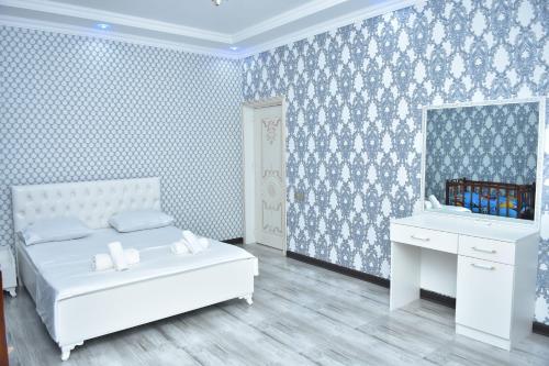 a bedroom with a white bed and a white desk at Gabala White House in Gabala