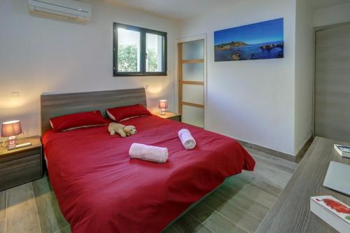 a large red bed with two stuffed animals on it at Appartements Supérieurs in Saint-Aygulf