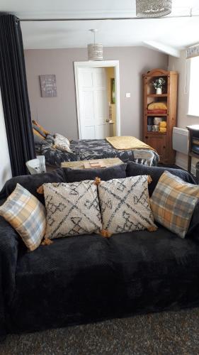 a room with two beds and a couch with pillows at Thyme Cottage in Whitby