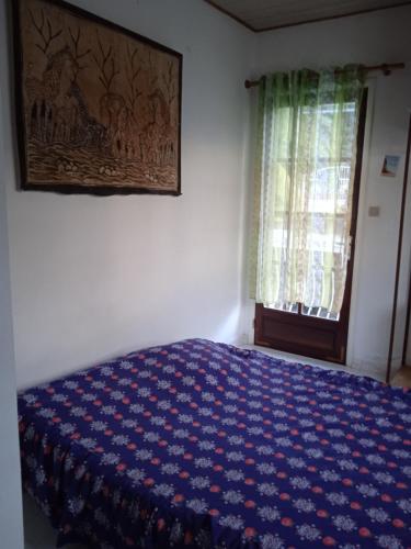 - une chambre avec un lit bleu et une fenêtre dans l'établissement La Kaz Kika, à Saint-Denis