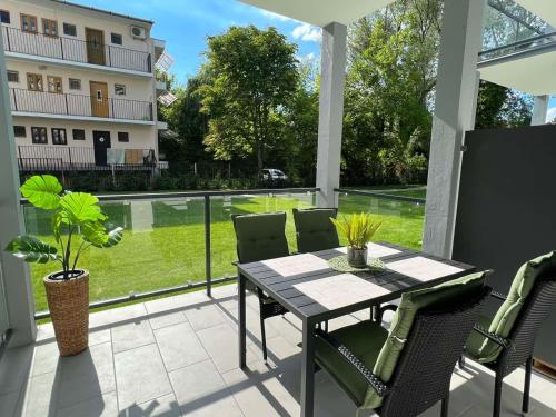 a patio with a table and chairs and a view of a building at Zamárdi Margittai Apartmanok in Zamárdi