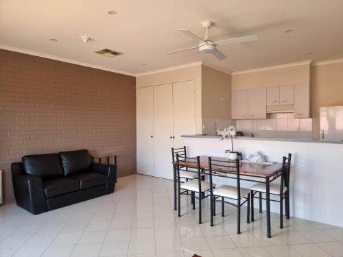 een keuken en eetkamer met een tafel en een bank bij Tuggeranong Short Stay #09 Sleeps 4 in Tuggeranong