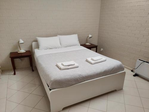Una cama blanca con dos toallas encima. en Tuggeranong Short Stay #09 Sleeps 4, en Tuggeranong