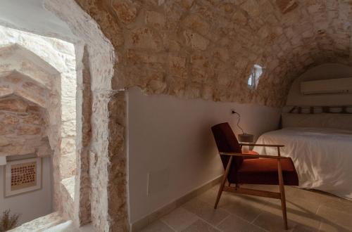 a bedroom with a bed and a table and a chair at Casa Antica Pietra Ostuni in Ostuni