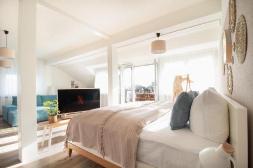 1 dormitorio blanco con 1 cama y TV en Löwe Apartments "Blau" Neuhausen am Rheinfall en Neuhausen am Rheinfall