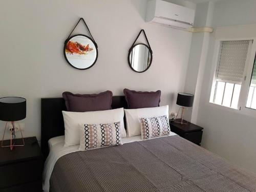 sypialnia z łóżkiem z dwoma lustrami na ścianie w obiekcie Beautiful apartment in La Carihuela, Torremolinos w mieście Torremolinos