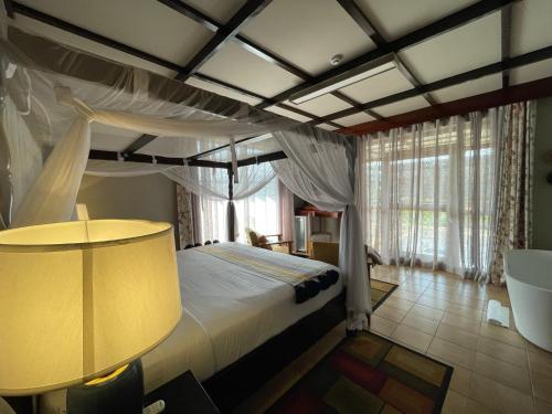 1 dormitorio con cama con dosel y lámpara en Governor's Residence, en Kigali