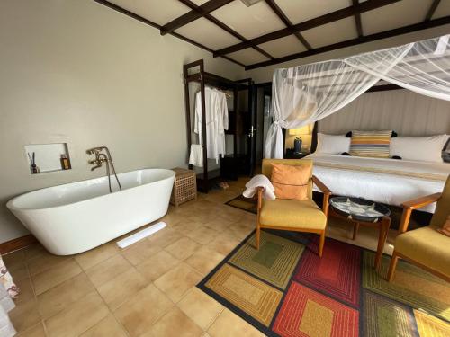 a bathroom with a bath tub and a bed at Governor's Residence in Kigali