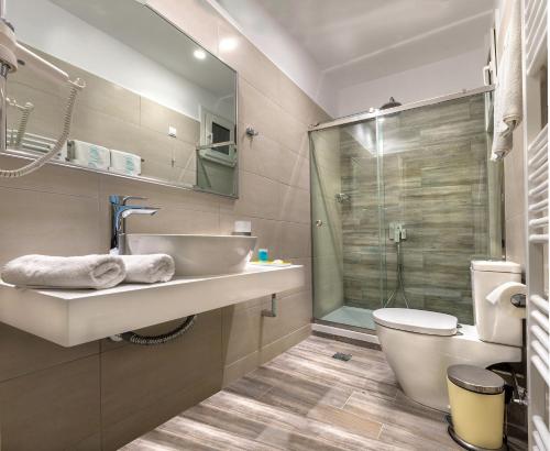 y baño con lavabo, aseo y ducha. en Hotel Strass, en Paralia Katerinis