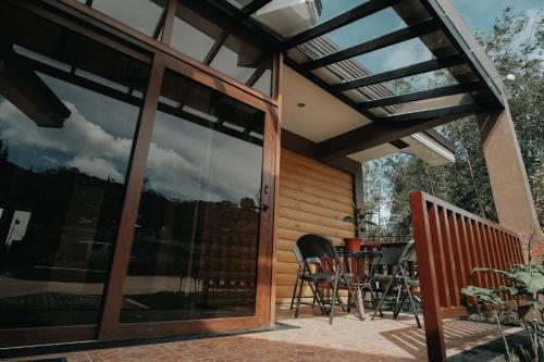 a patio with glass doors and a table and chairs at 150 Peakway Mountain Resort in Dalaguete