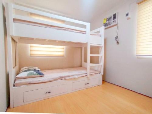 ein weißes Etagenbett mit einer Leiter in einem Zimmer in der Unterkunft Cozy 3BR Home with Garden, Pool & Modern Comforts in Angeles