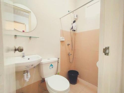 een badkamer met een toilet, een wastafel en een spiegel bij Cozy 3BR Home with Garden, Pool & Modern Comforts in Angeles