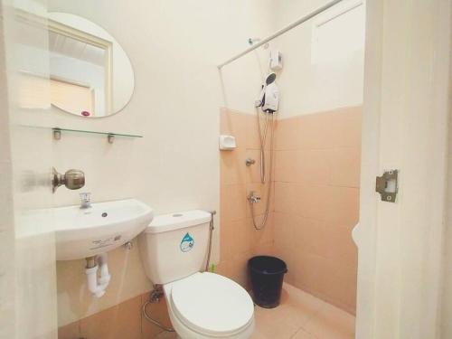a bathroom with a toilet and a sink and a mirror at Cozy 3BR Home with Garden, Pool & Modern Comforts in Angeles