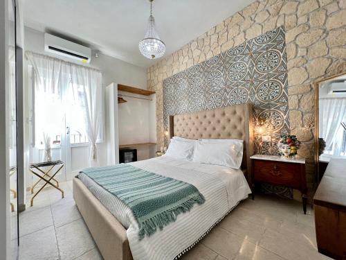 a bedroom with a large bed and a stone wall at Incanto Siciliano in Noto