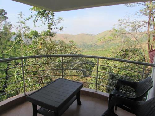 a balcony with a bench and a view of a mountain at Falcon Crest in Vagamon