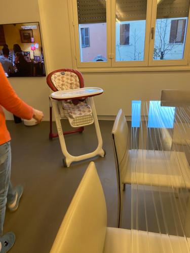a person standing next to a table and a chair at Cortirola luxury apartment in Pesaro