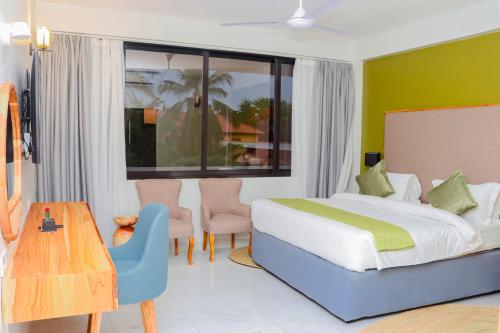 a bedroom with a bed and a table and chairs at Jangwani Sea Breeze Resort in Dar es Salaam