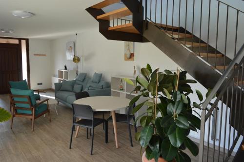 sala de estar con mesa y sillas y escalera en Mas Piua, en Girona