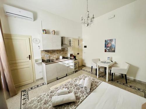 a kitchen with a table and a dining room at Made in Ortigia Apartments in Siracusa