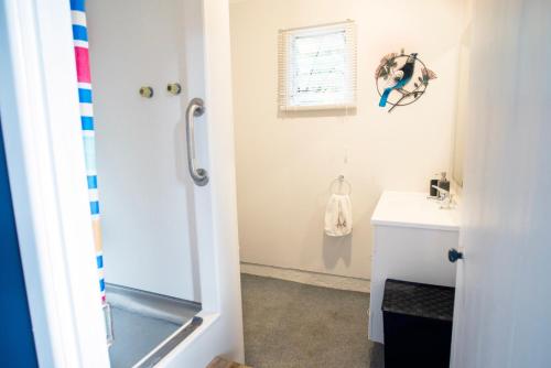 La salle de bains est pourvue d'une douche et d'un lavabo. dans l'établissement Nigel's Crib - Coopers Beach Holiday Home, à Coopers Beach
