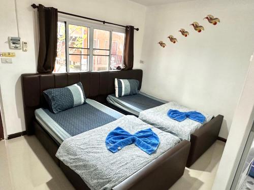 een slaapkamer met twee bedden met blauwe bogen erop bij Kalae Resort in Ban Nong Ben