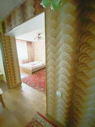 a living room with a wall with a mirror at Квартира напротив Аэропорта in (( Turksib ))